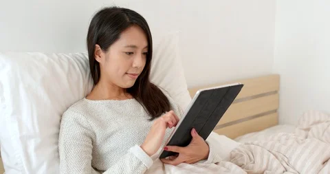 Woman use of tablet computer on bed Stock Footage 87864388