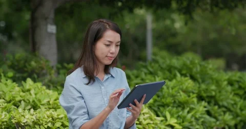 Woman use of tablet computer at outdoor Stock Footage 132016154