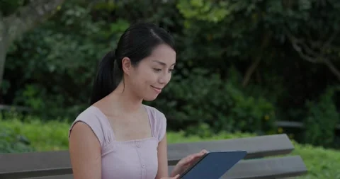 Woman use of tablet computer at park Video stock 131049835