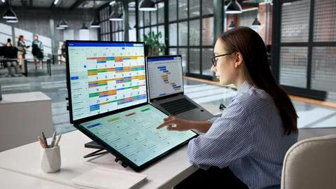 Woman Uses Calendar Software On Computer To Plan Project Schedule. Stock Photos