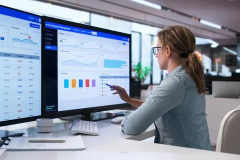 Woman Uses Computer System To Track Facility Service Requests Quickly And Eff Foto stock