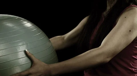 Woman uses exercise ball to do arm squeezes Stock Footage 33831363