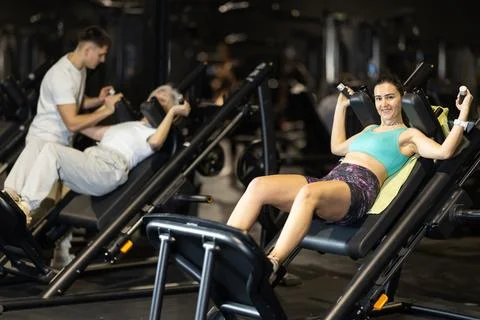 Woman uses hack squat machine to strengthen muscles Stock Photos
