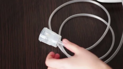 A woman uses a nebuliser for asthma and lung disease at home.Mouthpiece for Stock Footage