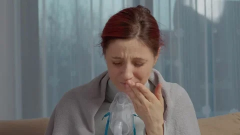 Woman uses nebulizer with saline solution for cough and respiratory relief Stock Footage 346706193