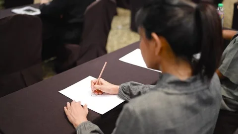 A woman uses a pen to write notes on the desk in the office room. Stock Footage 256974267