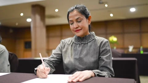 A woman uses a pen to write notes on the table. Stock Footage 256974268