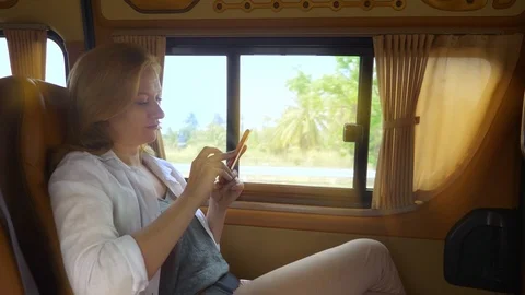 A woman uses the phone while sitting in the passenger seat of a minivan. Stock Footage 101008065