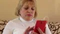 Woman uses red smartphone with earphones HD Footage