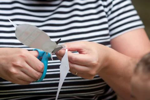 Woman uses scissors to cut pattern for child's art project Foto stock
