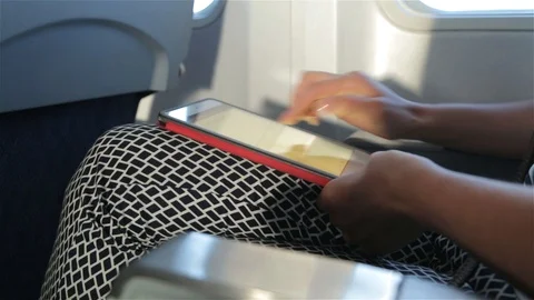 Woman uses tablet computer touchscreen in the plane (close-up) Stock Footage 98121981