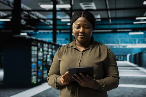 Woman uses tablet to implement security measures fortifying data center Foto stock