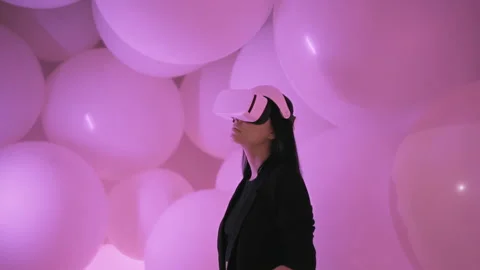 Woman uses virtual or augmented reality glasses in cyber space with pink light Stock Footage 217538111
