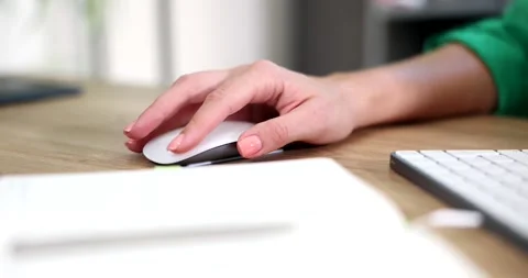 Woman uses white computer mouse on wooden desk with keyboard Stock Footage 307906839