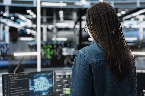 Woman using AI tech in server room storing data used for machine learning Stock Photos