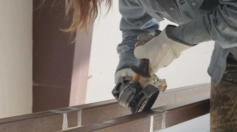 Woman using angle grinder outside metal shop Stock Footage 56863746