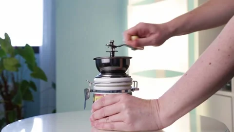 Woman using an antique coffee grinde Stock Footage 143464337