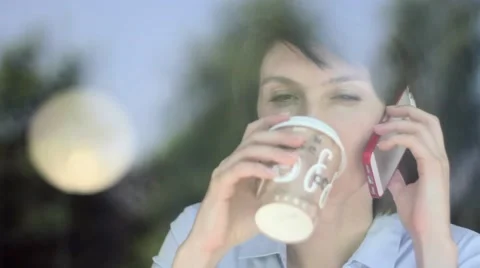 Woman using app on smartphone in cafe drinking coffee smiling and texting on Stock Footage 63757283