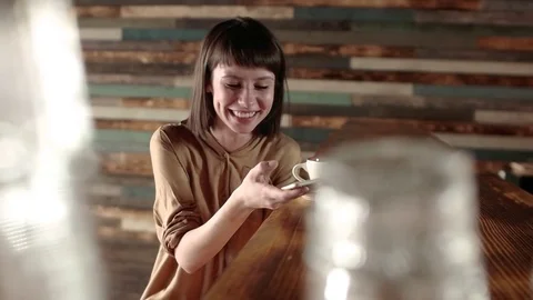 Woman using app on smartphone in cafe happy facial expression and texting on Stock Footage 72816896