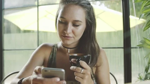 Woman using app on smartphone in cafe drinking coffee working on mobile phone Stock Footage 73054530