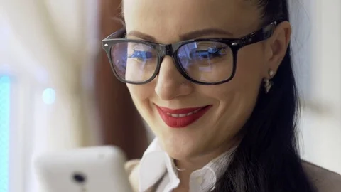 Woman using app on smartphone in cafe drinking coffee smiling and texting on Stock-Footage 73416689