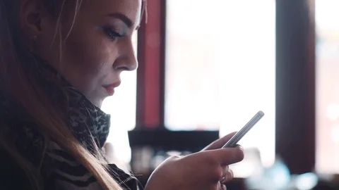 Woman using app on smartphone in cafe drinking coffee smiling and texting Stock Footage 74011827