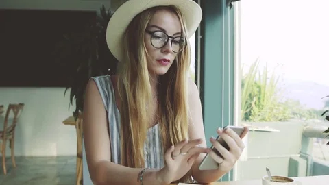 Woman using app on smartphone in cafe drinking coffee and smiling. Stock Footage 74367269