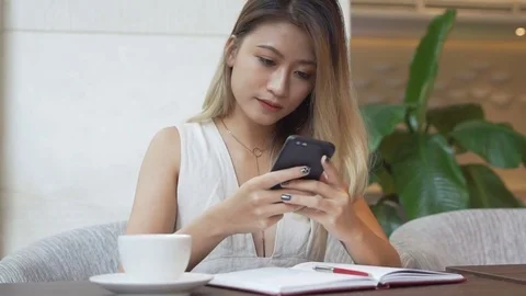 Woman using app on smartphone, drinking coffee, smiling, texting on mobile phone Stock Footage 79293345
