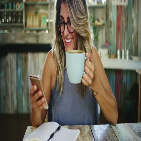 Woman using app on smartphone texting and drinking coffee in a cafe Stock Footage 69391521