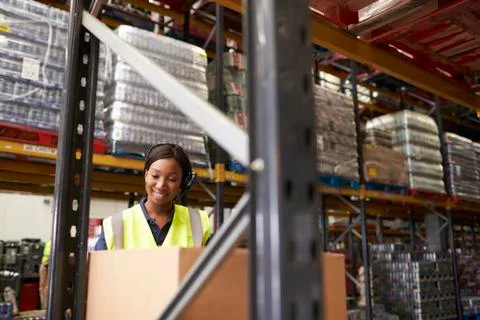 Woman using barcode reader in warehouse, head and shoulders Stock Photos