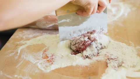 Woman using bench scraper to mix beet flour into pasta dough Stock Footage 199152518