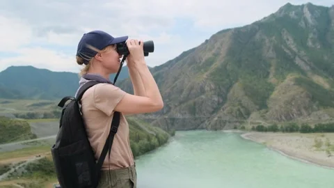 Woman using binoculars while hiking in mountains. Stock Footage 297752662