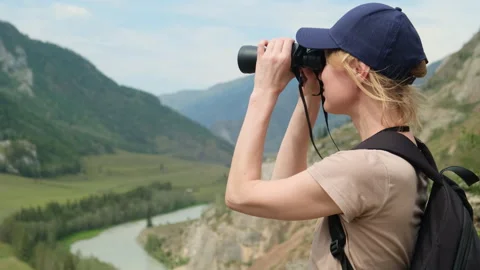 Woman using binoculars while hiking in mountains. Stock Footage 299925368