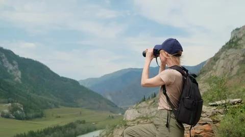 Woman using binoculars while hiking in mountains. Stock Footage 302780056