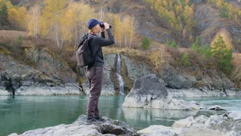 Woman using binoculars while hiking in mountains. Stock Footage 304953858