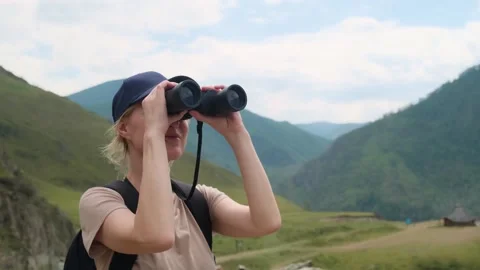 Woman using binoculars while hiking in mountains. Stock Footage 304957527
