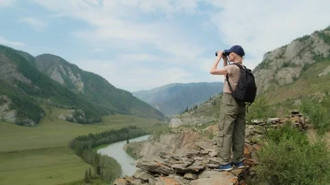 Woman using binoculars while hiking in mountains. Stock Footage 304957550