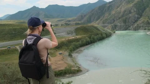 Woman using binoculars while hiking in mountains. Stock Footage 306029763