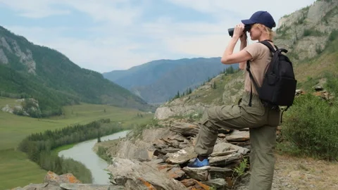 Woman using binoculars while hiking in mountains. Stock Footage 310867976