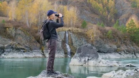 Woman using binoculars while hiking in mountains. Stock Footage 312242680