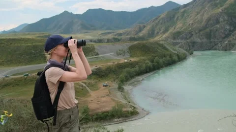 Woman using binoculars while hiking in mountains. Stock Footage 327893950