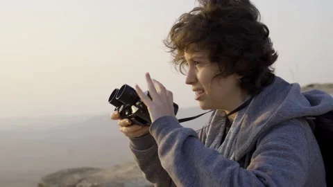 Woman using binoculars the wrong way then corrects herself - desert scenery Stock Footage 143643157