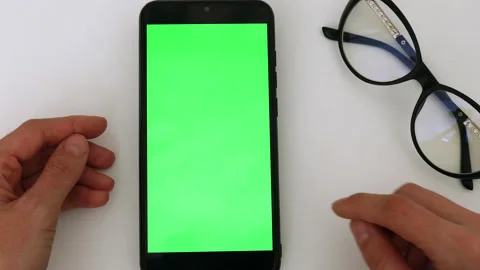 Woman using black smartphone device with green screen. Woman holding mobile phon Stock Footage 219791810