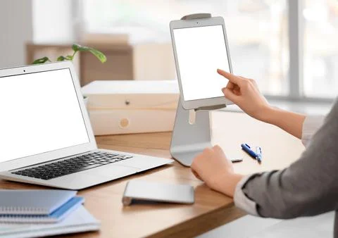 Woman using blank tablet computer at table in office, closeup Stock Photos