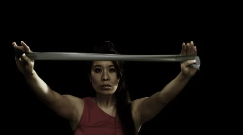 Woman using a bungee cord to stretch while exercising Stock Footage 33831432