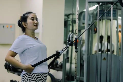 Woman using a cable machine at the gym Stock Photos