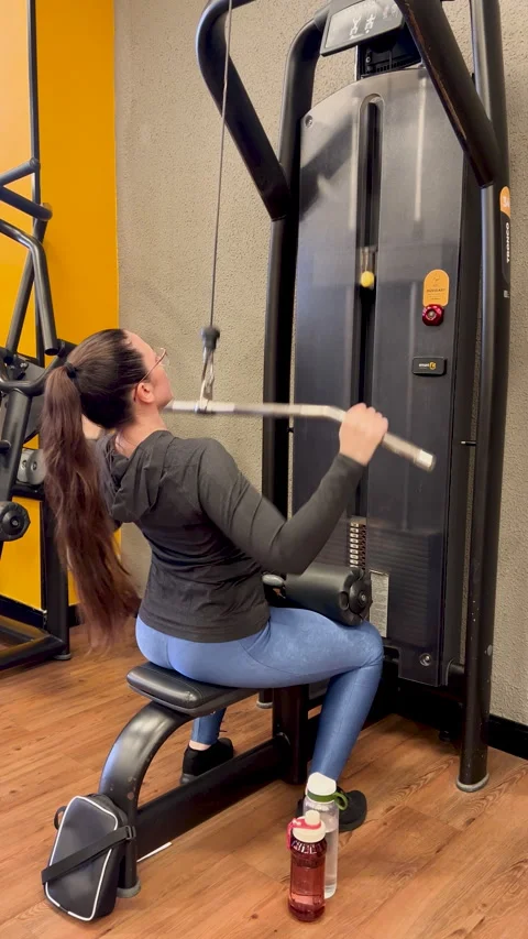 Woman using cable row machine at gym - muscle strength training vertical view Stock Footage 337266625