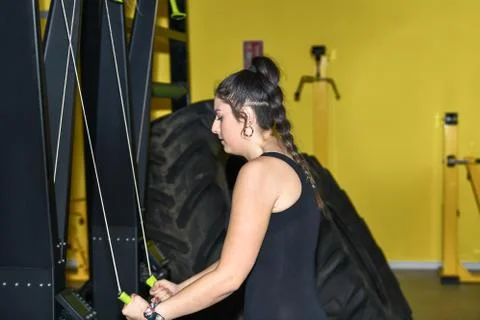 Woman using a cable row machine at the gym Stock Photos