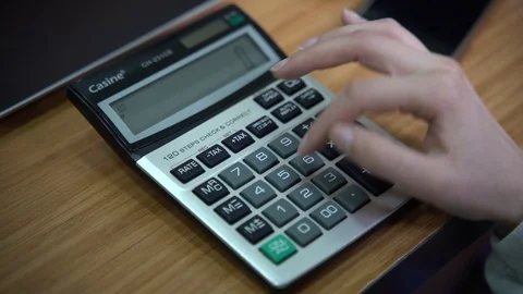 Woman using calculator to solve math equations - Handheld 4k shot Stock Footage 125542005