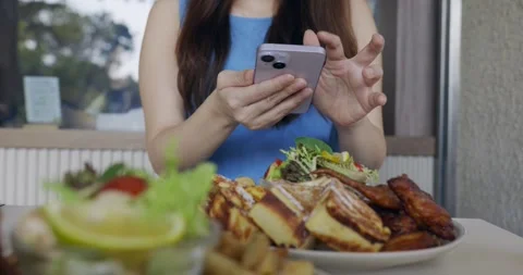 Woman using the camera function on her smartphone to capture pictures of food. Stock Footage 257043716